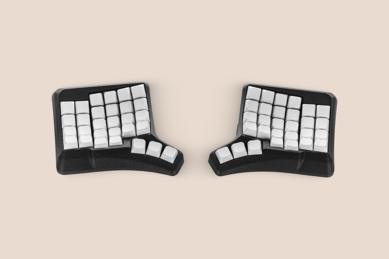 Phenom Standard split ergonomic keyboard with white keycaps in a black sculpted case